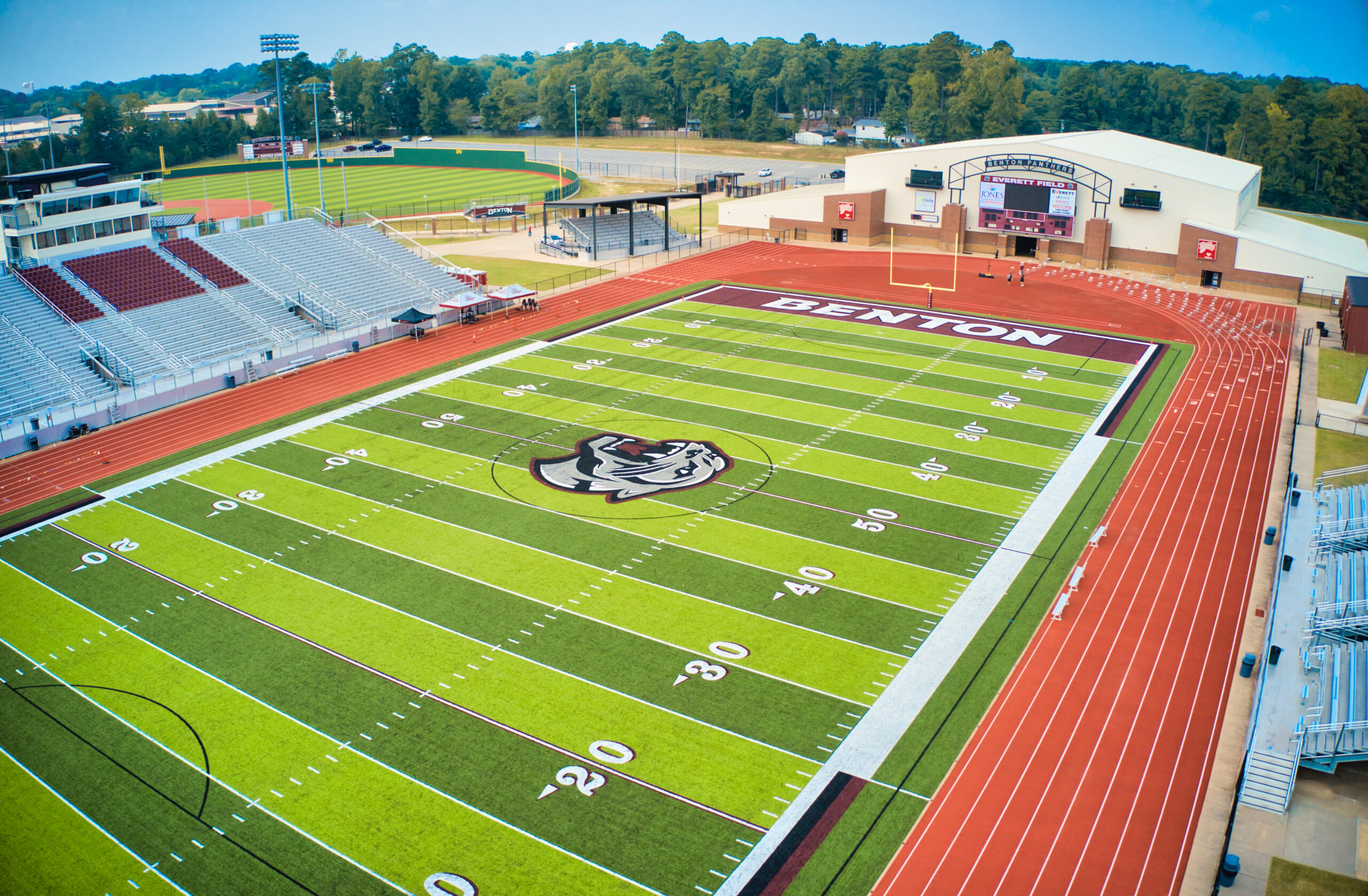 Aerial view of a high school stadium with a football field, running track, and perimeter fencing